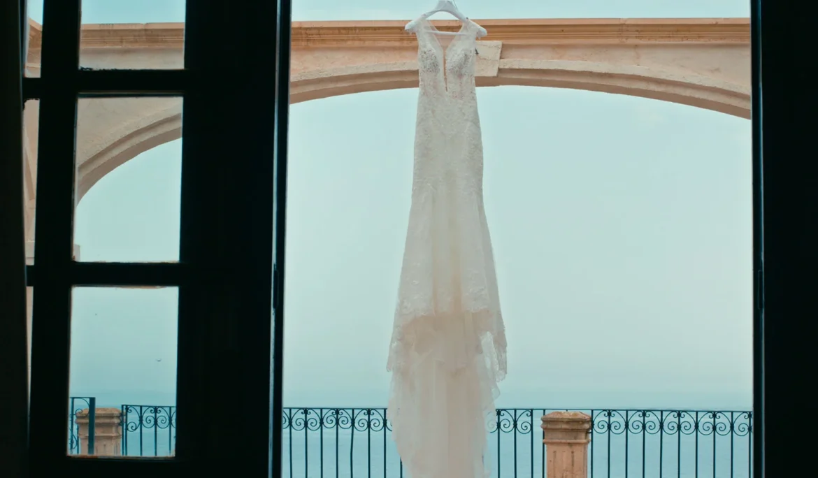 The wedding dress hangs in front of a stunning ocean backdrop in Florida.